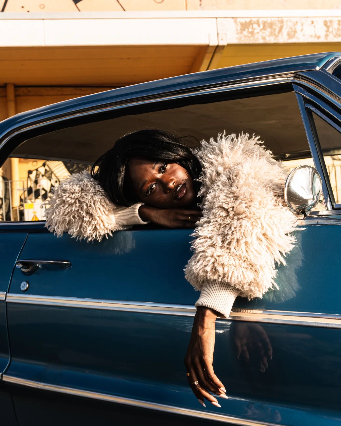 A portrait framed by the window of a vintage car.