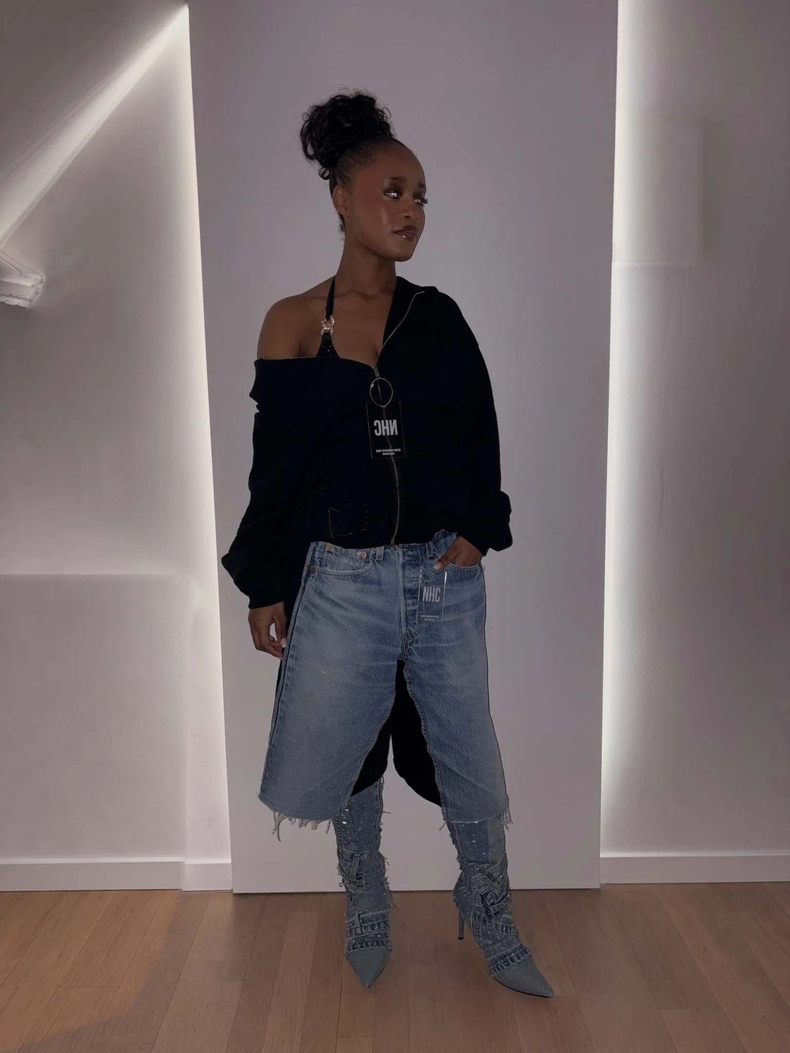 An asymmetric black jacket, denim shorts and embellished denim boots.