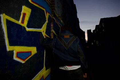 An outdoor view of the rear of the denim jacket.