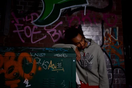 A relaxed pose beside the wall in the grey knit look.