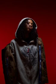 A grey knit layer beneath an oversized camouflage jacket.