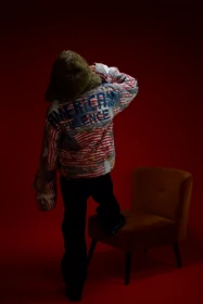 The back of a textured patchwork jacket with a faux-fur hood.