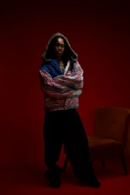 A complete look in the patchwork jacket beside a studio chair.